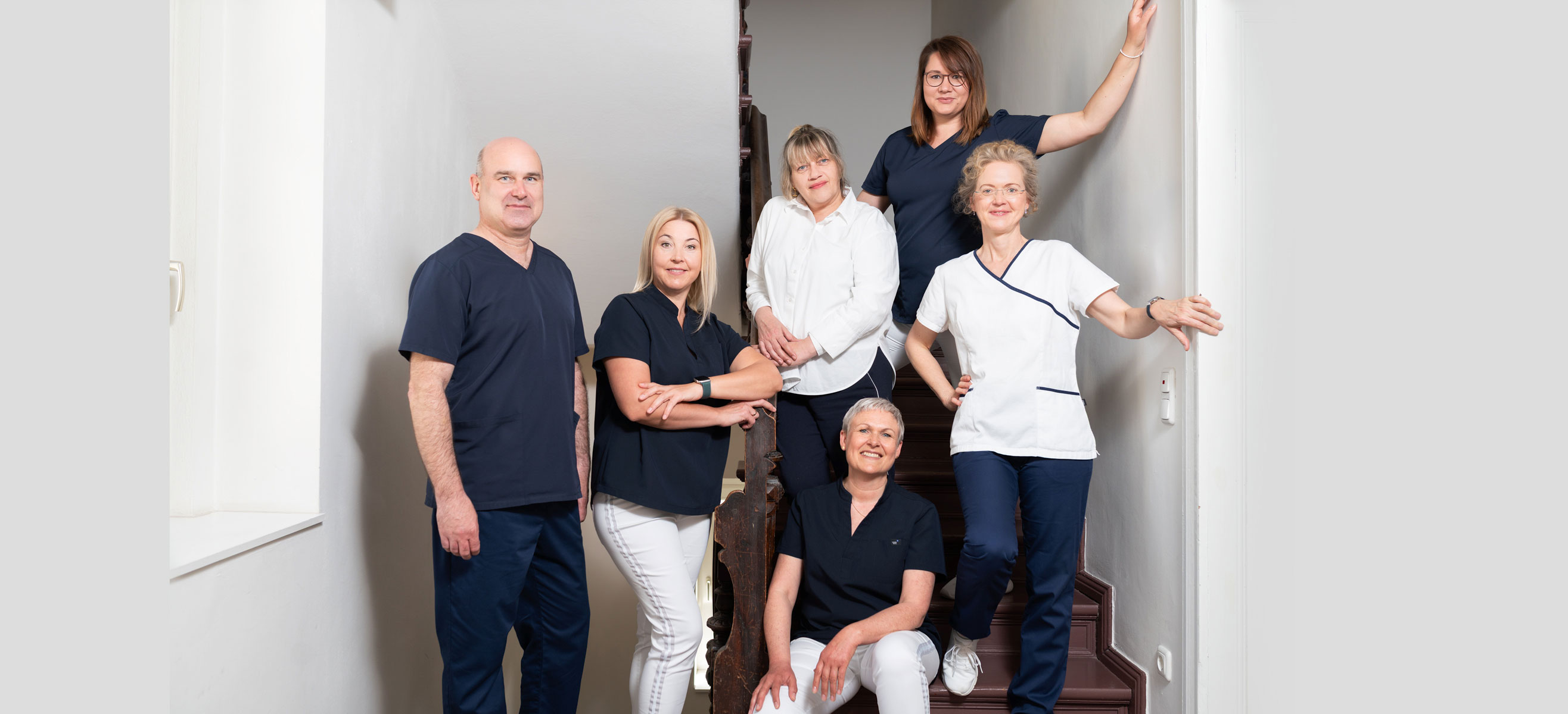 Das Team der Zanarztpraxis Schwarze im Treppenhaus.
